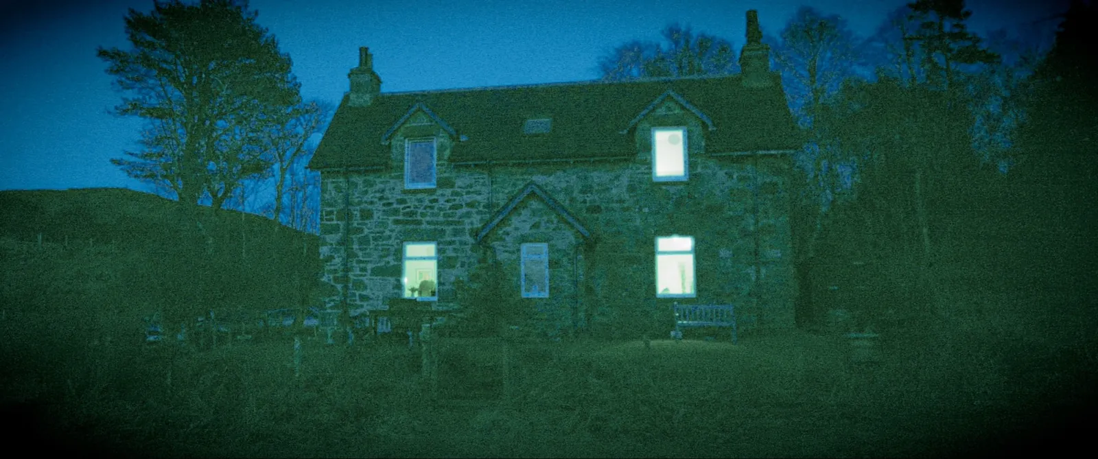 The cottage at night, lights on inside